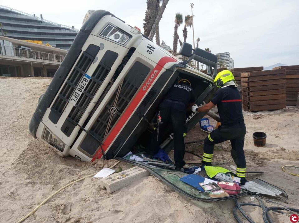 Policía Local de Alicante y bomberos del SPEIS intervienen para asegurar y neutralizar en un accidente con vuelco de un camión hormigonera un derrame de gasoil en la playa de San Juan