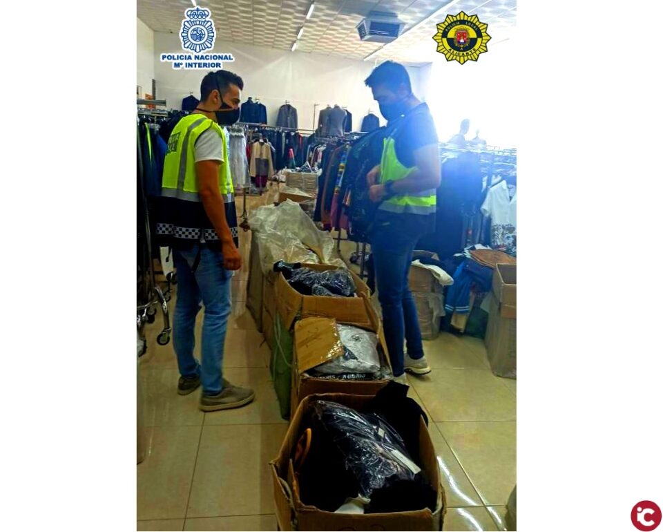 La Policía Nacional con la colaboración de la Policía Local de Alicante desmantelan un punto de distribución de productos falsificados con cuatro detenidos y miles de prendas incautadas
