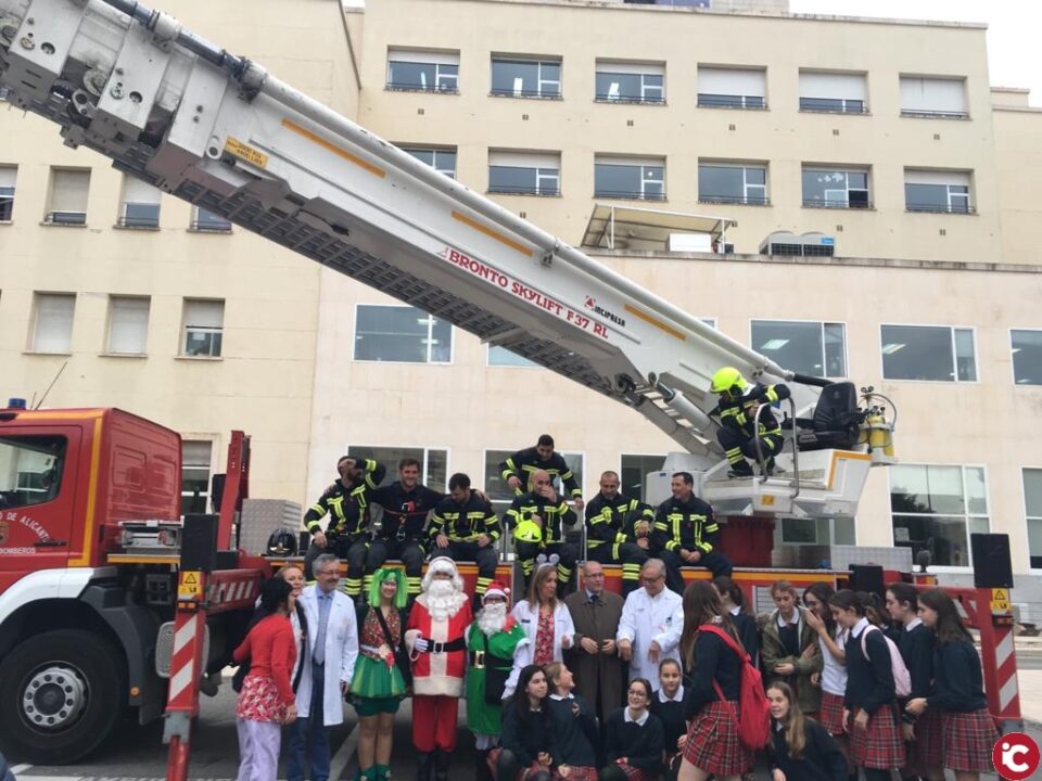Los bomberos del SPEIS llevan a Papa Noel con el vehículo escalera a las plantas de Pediatría y Oncología infantil del Hospital General de Alicante para entregar regalos e ilusión a los menores ingresados