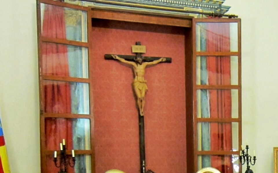 El ayuntamiento de Biar tapa durante los actos oficiales al Cristo que preside su salón de plenos