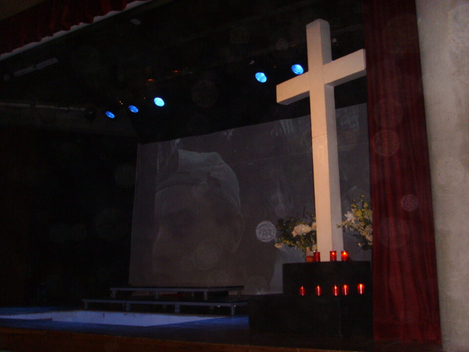 LA SEGUNDA ESTACIÓN DEL VIA CRUCIS SE HACE EN LA PUERTA DE LA CASA DE CULTURA. MODERACIÓN Y RESPETO POR PARTE DE LOS PARTICIPANTES DEL VIA CRUCIS Y PÚBLICO DE LA OBRA DE LEO BASSI